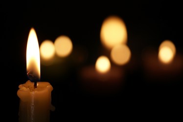 One Burning Candle With A Dark Background