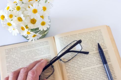 bigstock-Glasses-In-Hand-On-An-Old-Book-240896221